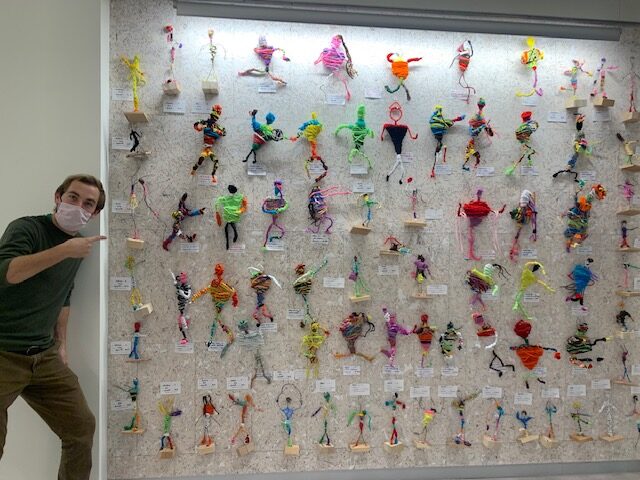 Mr. Norrbom near an array of 3D wire human sculptures made out of colorful pipe cleaners