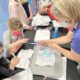 Students explore water pollution with a piece of paper, food dye and water.