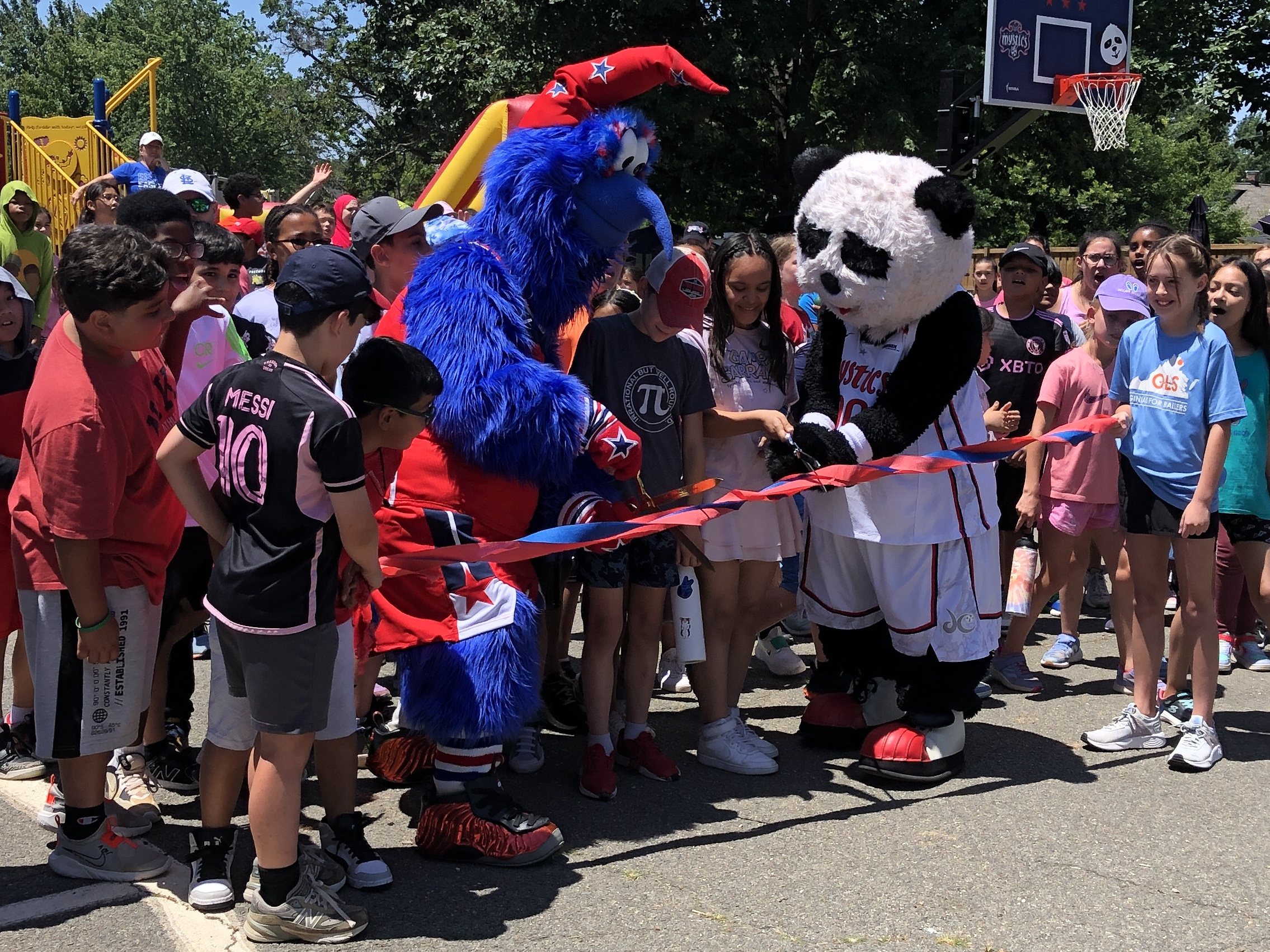 Mascots from the Washington Wizards and Mystics at a Ribbon Cutting Ceremony for new basketball hoops